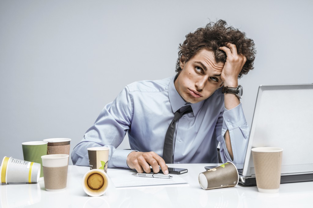 Distressed young manager man holds her head with hand